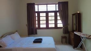 a bedroom with a bed and a large window at KaLong Bay Homestay Villa Seroja in Kampong Telok Kalong