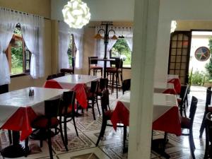a dining room with tables and chairs and a chandelier at Pousada Bem Querer in Penedo