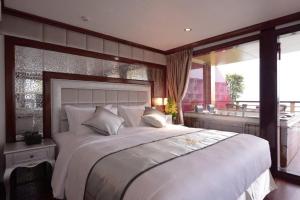 une chambre avec un grand lit et une grande fenêtre dans l'établissement Golden Cruise luxury, à Hạ Long 38 autres photos