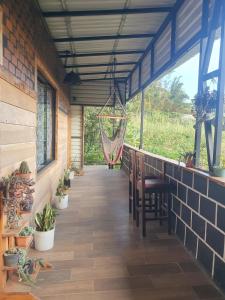 a porch with chairs and a hammock in a house at El Chagüite monteverde #2 in Monteverde Costa Rica
