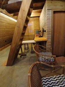 a room with a wooden staircase and a table at Cabana Villa Caju in Praia dos Algodões