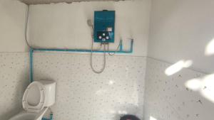 a bathroom with a toilet and a phone on the wall at Yut Homestay in Pang Ung