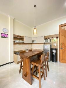 a kitchen with a wooden table and chairs at Villa Lisha Orolas in Blimbing