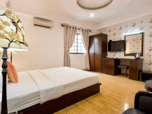 a bedroom with a bed and a desk in it at Little Brick Saigon Hotel in Ho Chi Minh City
