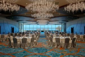 克拉布德品斯Sheraton Club des Pins Resort的有桌椅和枝形吊灯的宴会厅 更多37张照片