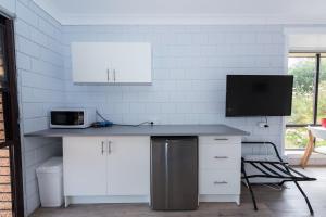 a kitchen with a counter with a microwave and a tv at Ocean Dreams in Bicheno