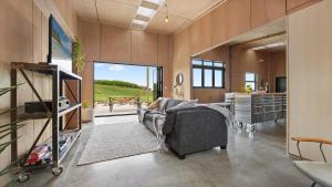 a living room with a couch and a table at OkiOki Stay Rural escape in Raglan
