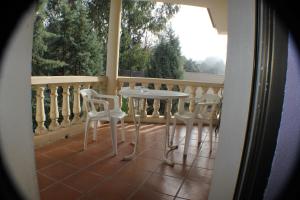 d'une table et de chaises blanches sur un balcon. dans l'établissement Hotel Las Nieves, à Las Nieves