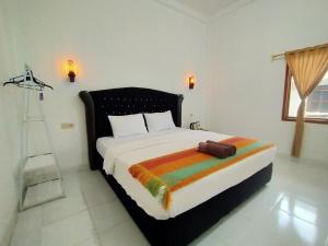 a bedroom with a large bed with a colorful blanket at Tania Homestay in Bumbang +14 photos