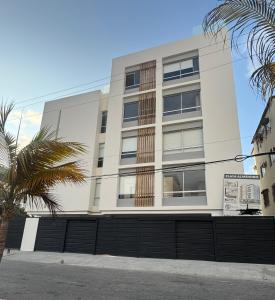 a white building with a fence in front of it at Suite For You - Salinas Chipipe in Salinas