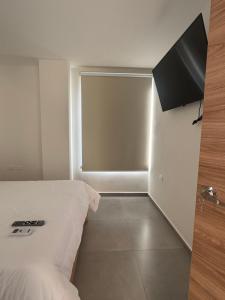 a hotel room with a bed and a window at Suite For You - Salinas Chipipe in Salinas