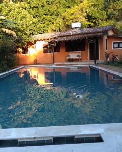 a swimming pool in front of a house at Casa Macacos in Porto Seguro