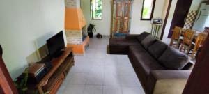 a living room with a couch and a tv at Casa Macacos in Porto Seguro