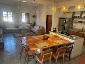 a kitchen and living room with a wooden table and chairs at Casa Amor Com Vista para o Mar in Ponta do Funil
