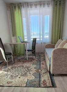 a bedroom with a bed and a table and chairs at Квартира рядом с Караколом in Karakol