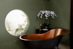 a bath tub in a bathroom with a mirror at Villa Tria Laweyan Solo in Purwosari
