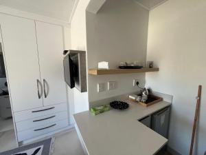 a kitchen with white cabinets and a counter top at The Noble Lodge in Cape Town