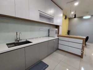 Una cocina con gabinetes blancos y un fregadero. en dotMy Homestay Kluang 15 pax - NETFLIX - WiFi - Autogate - 4 Rooms - 4 Bathrooms, en Keluang