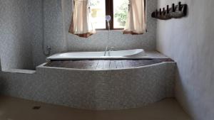 a bath tub in a bathroom with a window at Rara Villas Lombok in Senggigi