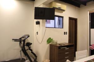 a room with a treadmill and a television on the wall at Stefanich Aparthotel 2122 in Ciudad del Este