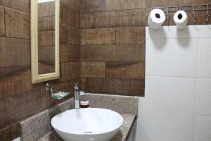 a bathroom with a white sink and a mirror at Stefanich Aparthotel 2122 in Ciudad del Este +27 photos