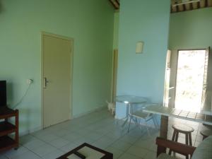 a room with a table and a table and a door at Ekoara Bangalos in Jacumã