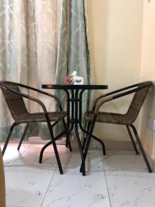 a black table and two chairs next to a window at Capsule Queens Luxury Studio in Mombasa +9 photos