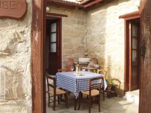uma mesa com cadeiras e uma toalha de mesa azul e branca xadrez em Niovi House em Tochni