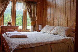 a bedroom with a bed and a window at Cabañas Shangrila Aysen in Puerto Aisén