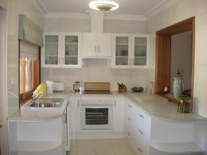 a kitchen with white cabinets and a sink at Apartments on Fiedler in Tanunda