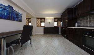 a kitchen with a counter and a table and chairs at Apartament AMBER in Brăila