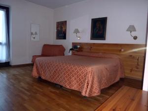 ein Schlafzimmer mit einem Bett und einem Stuhl in der Unterkunft Hotel Le Verger in Châtillon