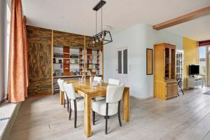 a dining room with a wooden table and white chairs at Eindhoven City Center Apartment in Eindhoven