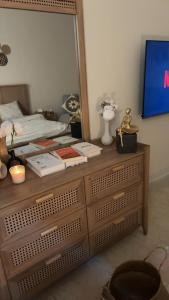 a bedroom with a bed and a dresser with a mirror at Deluxe Boho - Self Check-in in Riyadh