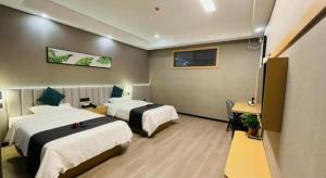 a hotel room with two beds and a television at Thank Inn Jiangsu Suqian Sucheng District Car Town in Suqian