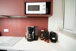 un bancone cucina con macchinetta del caffè e forno a microonde di BoX 27 a Kalamáta