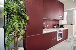una cucina con armadi rossi e una pianta in vaso di BoX 27 a Kalamáta