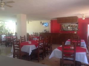 Hotel Real Santa María في كويرنافاكا: مطعم بجدران حمراء وطاولات وكراسي خشبية