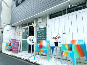 a table with colorful chairs in front of a store at Ohmachi Junxion in Kamakura
