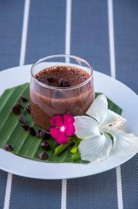 a cup of coffee on a plate with a flower at Le Bouton D'or Boutique Hotel in Thakhek