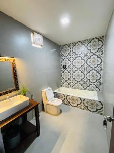 une salle de bain avec un lavabo, des toilettes et une baignoire dans l'établissement Arabian Sea Beach Resort, à Morjim