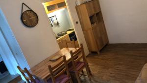 a dining room with a table and a clock on the wall at Appartement 6 pers Eaux-Bonnes! in Eaux-Bonnes