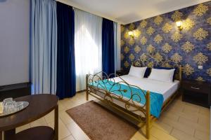 a bedroom with a bed with a blue and gold wallpaper at Villa LUI-JO in Krasnodar