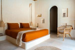 a bedroom with a large bed and a chair at Kiki's Villa in Gili Air +9 photos