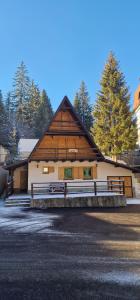 duży drewniany dom z płotem przed nim w obiekcie Holiday home Bella Vlašić w mieście Šišava