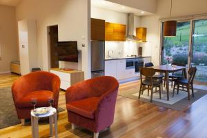 a kitchen and dining room with a table and chairs at Wilderberry Cottage in Berry