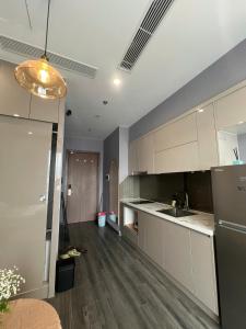 a kitchen with white cabinets and wooden floors at Căn hộ Homestay riêng tư khu Oceanpark Gia Lâm in Gia Lâm Pho +3 photos