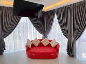 a red couch with pillows in a room with windows at CS Junction Point - Special Day Room SDR in Kuala Pilah