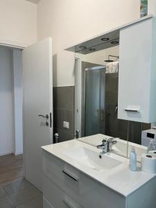 a white bathroom with a sink and a mirror at A 3 passi da tutto in Treviso +12 photos