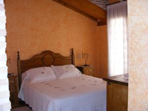 una camera da letto con un letto con lenzuola bianche e una finestra di Hotel Rural El Museo a Cedillo de la Torre